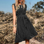 Frau strahlt in Polka-Dot-Sommerkleid unter freiem Himmel, Symbol für Eleganz und Stil.